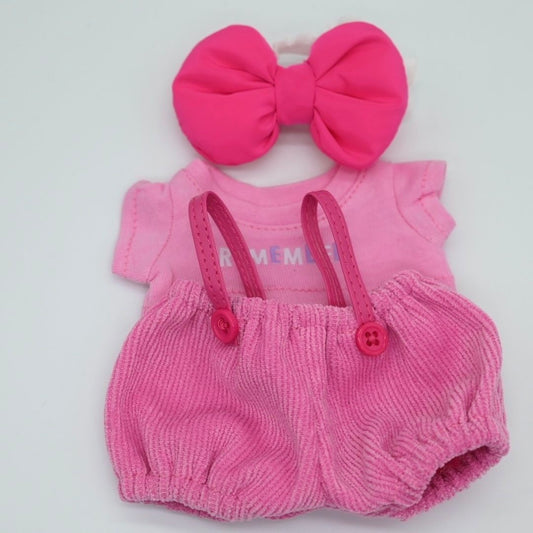 Pink baby romper with suspenders and a large pink bow on a white background