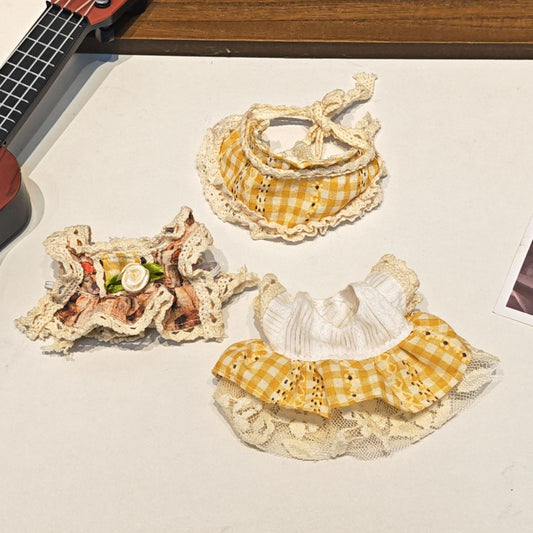 Three decorative lace collars with yellow and white patterns on a light surface.